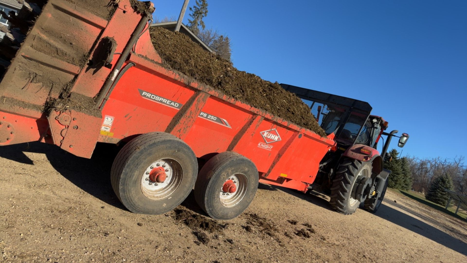 Loaded Kuhn ProSpread spreader behind a Case IH tractor